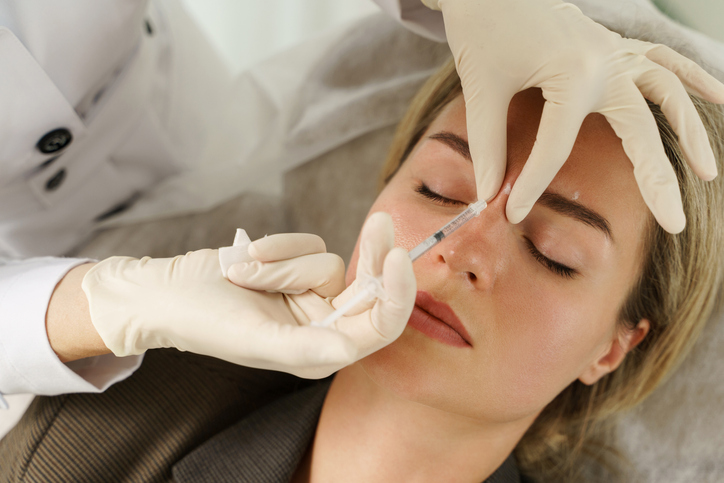 Woman during facial filler injections in aesthetic medical clinic